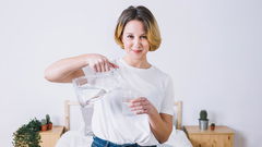 ragazza che versa acqua in un bicchiere