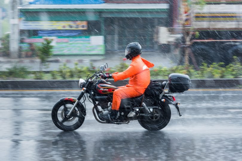 motociclica che indossa poncho per la pioggia