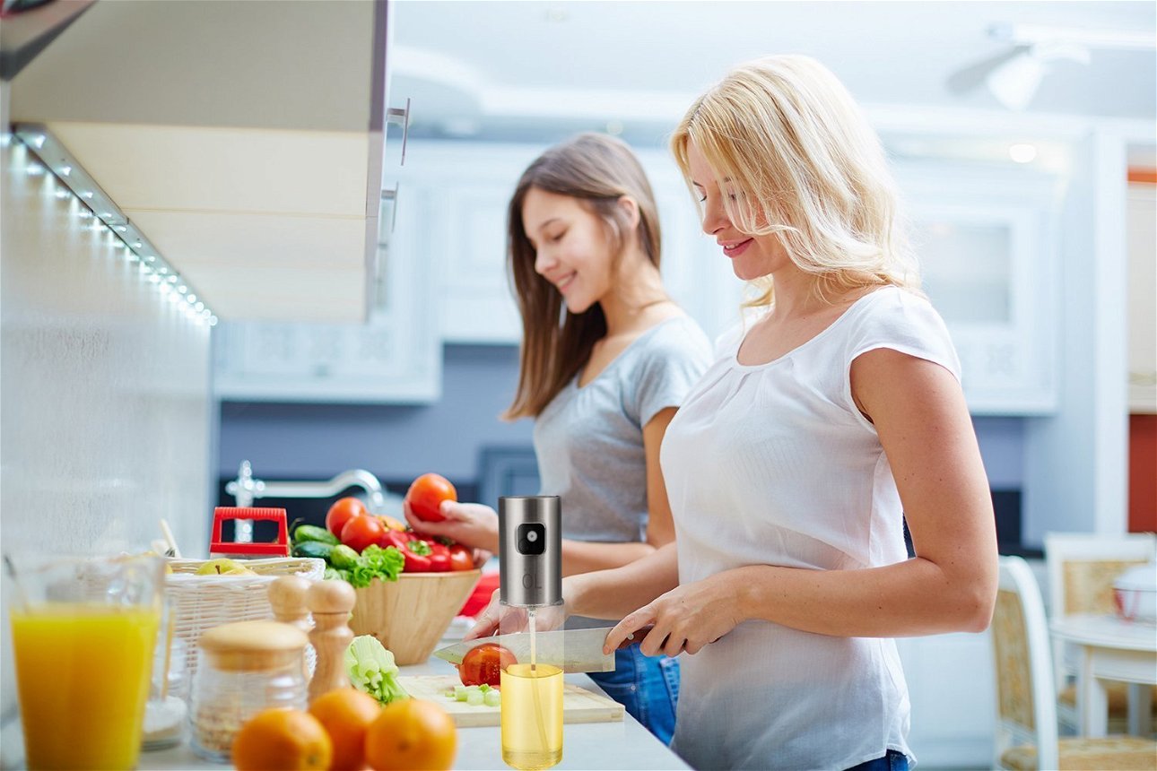 donne in cucina con oliera spray in primo piano