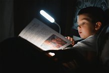 luce da lettura che illumina libro bambino a letto