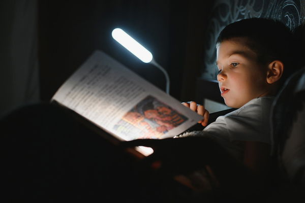 luce da lettura che illumina libro bambino a letto