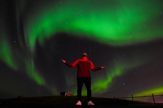 uomo sotto Aurora boreale islanda