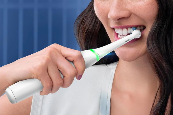 donna che usa spazzolino elettrico oral-b