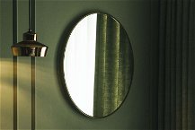 specchio da parete tondo su muro verde 