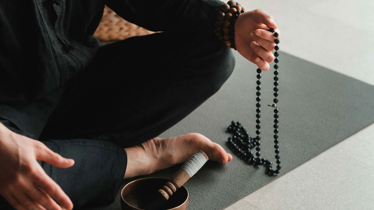 uomo che usa japamala in meditazione 