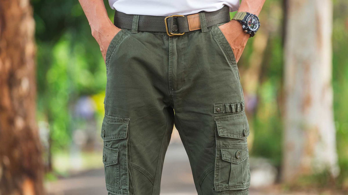 uomo che indossa pantaloni cargo verdi nella natura