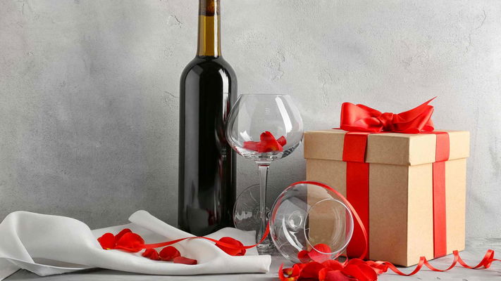 vino rosso con bicchiere e pacchetto regalo