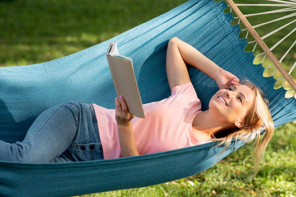 ragazza legge libro su amaca