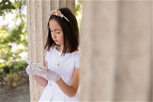 bambina legge libretto della prima comunione