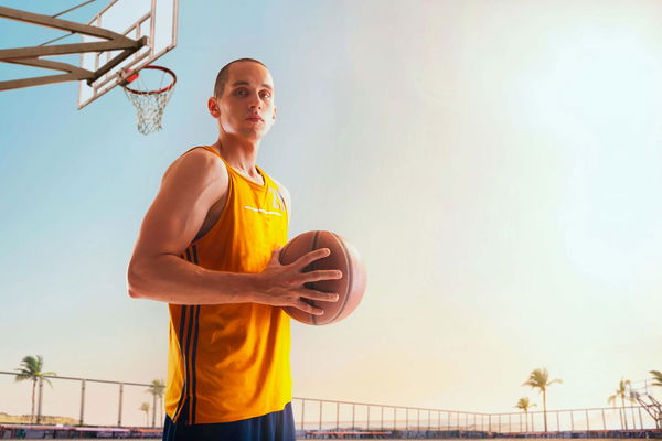 ragazzo con canotta da basket e pallone in mano