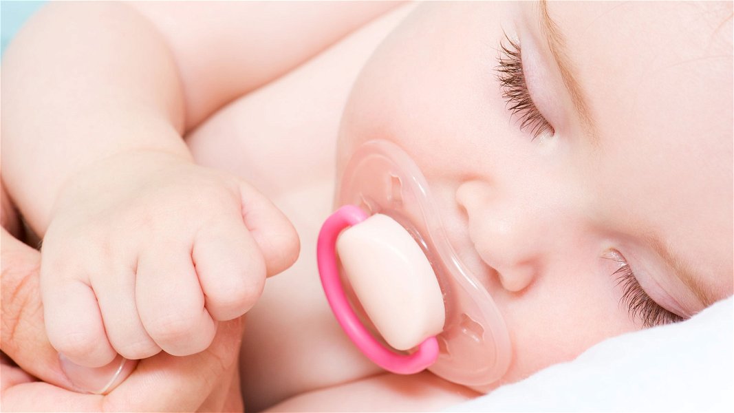 neonato dorme con ciuccio in bocca