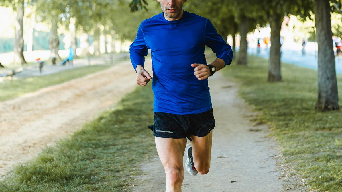 uomo che corre nel parco con pantaloncini da running