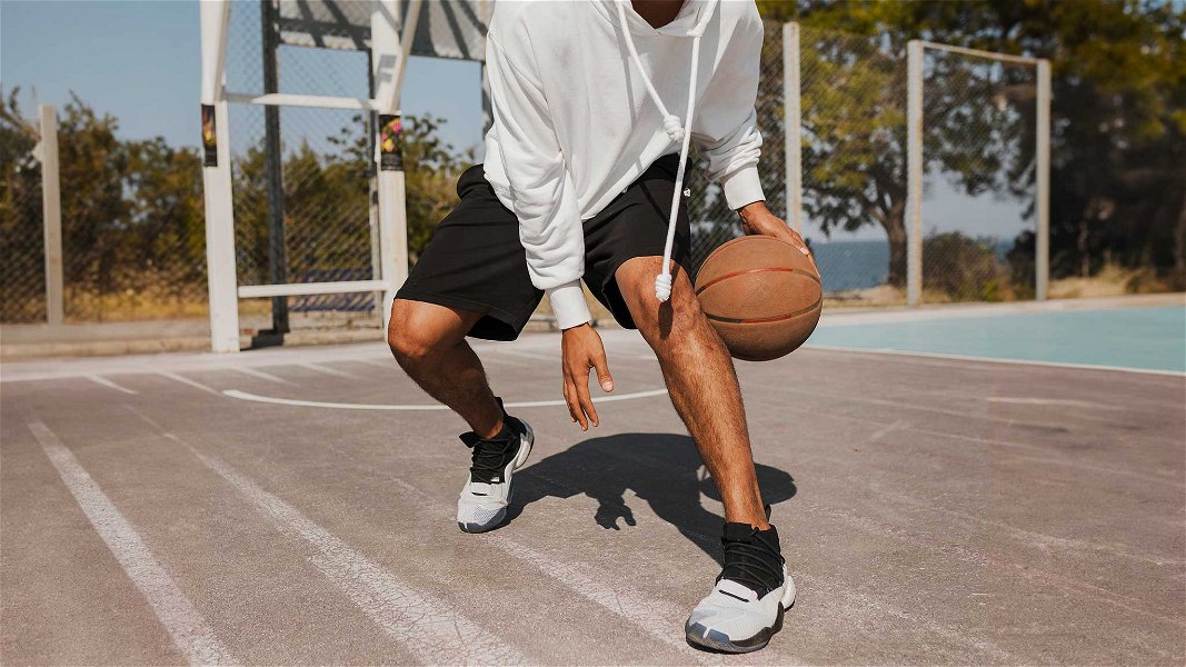 uomo che indossa pantaloncini da basket mentre gioca
