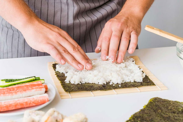 uomo prepara sushi