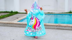 bambina che indossa poncho mare unicorno