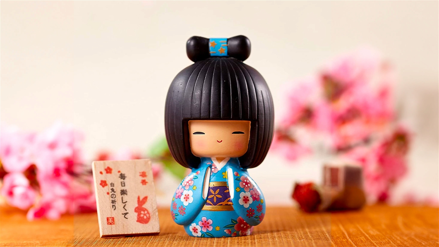 Kokeshi bambola giapponese celeste sfondo ciliegi