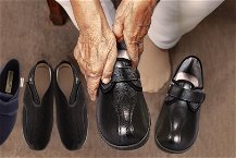 anziana che si infila scarpe nere