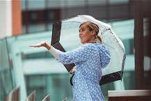 Donna in strada con ombrello trasparente