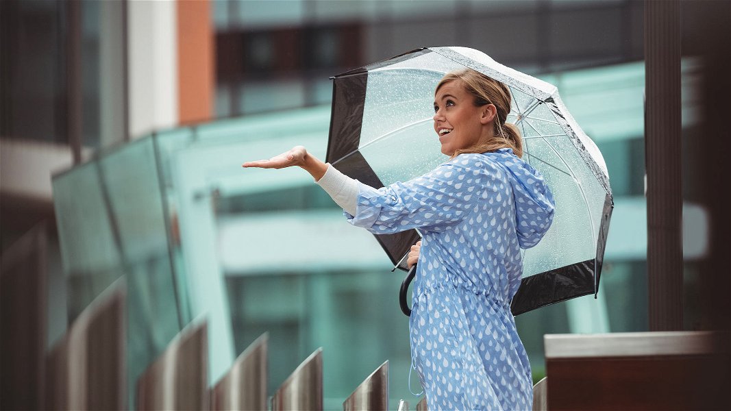 Donna in strada con ombrello trasparente