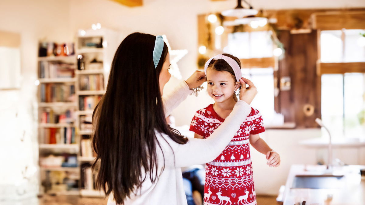 mamma che indossa cerchietto e lo mette addosso alla sua bambina in casa