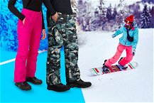 Pantaloni da sci comodi e tecnici in primo piano e snowborder nello sfondo