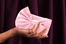 mano che tiene pochette rosa da cerimonia