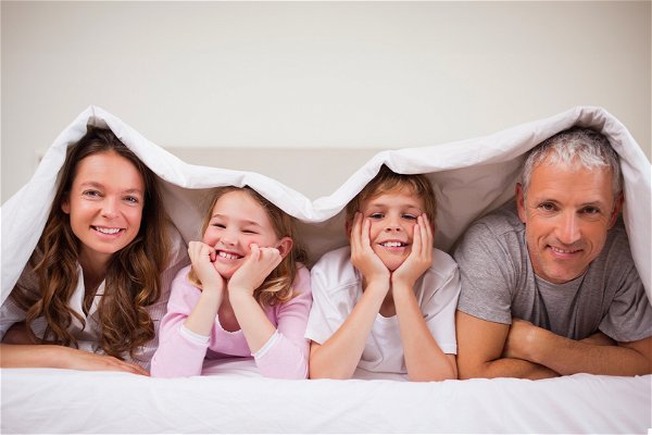 Famiglia felice a letto con intimo per uomo donna bambina e bambino