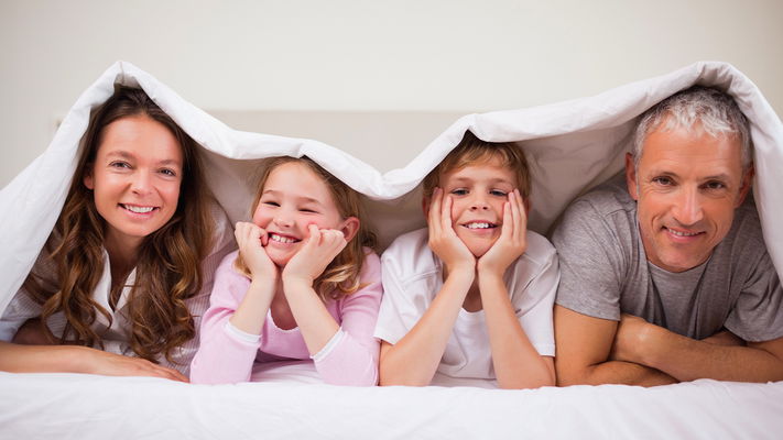 Famiglia felice a letto con intimo per uomo donna bambina e bambino