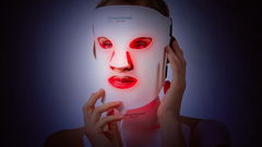 donna che usa maschera viso led antirughe accesa 