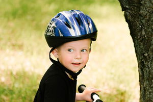 Bambino in bici con casco