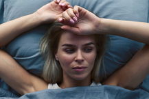 mezzo busto donna nel letto che soffre di insonnia vista dall'alto