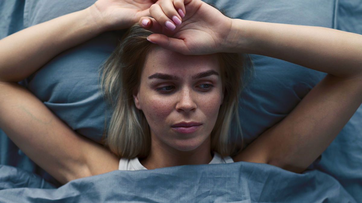 mezzo busto donna nel letto che soffre di insonnia vista dall'alto