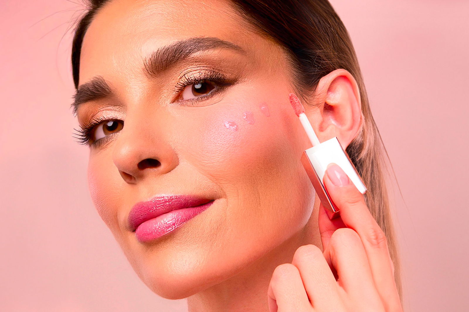 Donna che si applica il blush liquido sulla guancia