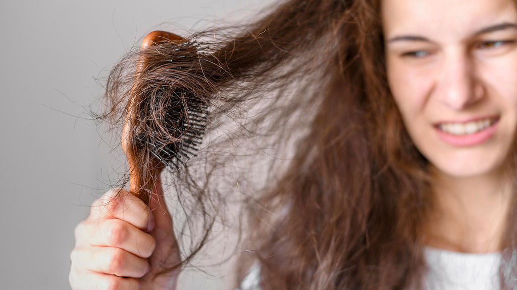 donna che fa fatica a pettinare i capelli