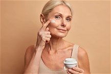 donna che si applica una crema al collagene sul viso