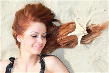 donna sdraiata capelli sulla sabbia