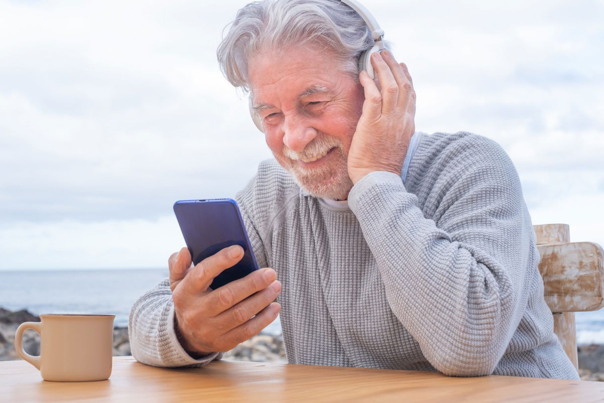 uomo anziano che guarda il cellulare felice