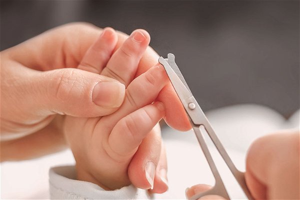 mamma taglia le unghie al neonato