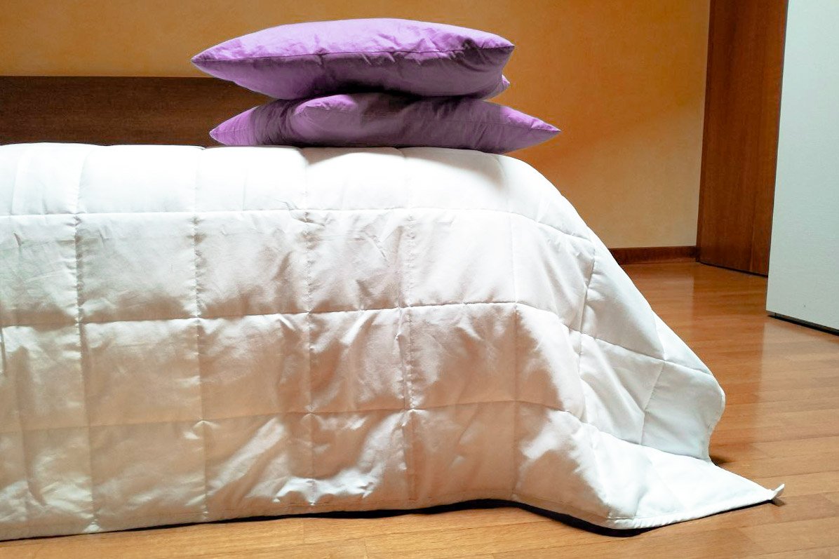 coperta ponderata sul letto con cuscini