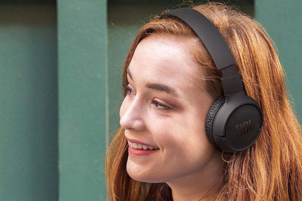 ragazza capelli rossi che indossa cuffie bluetooth economiche jbl 