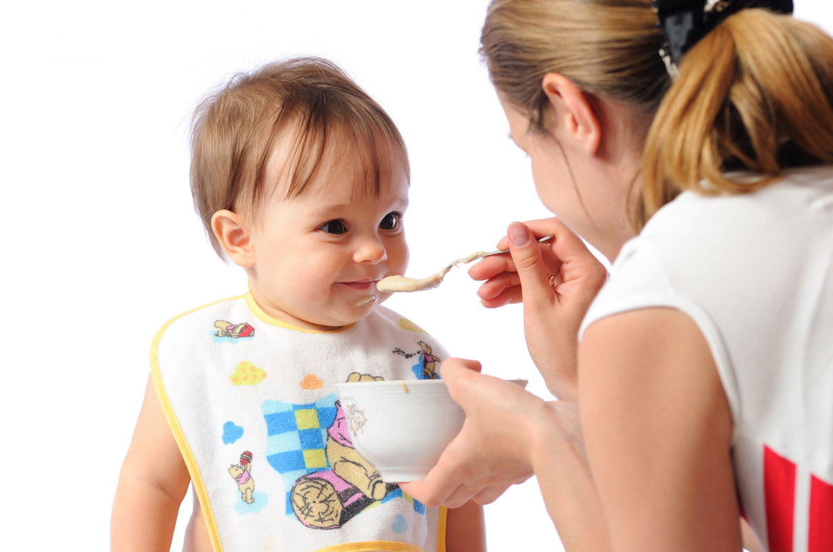 Mamma che imbocca il suo bambino