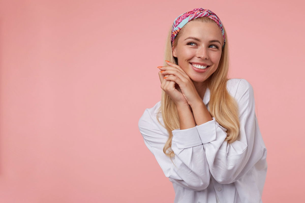 ragazza bionda con fascia per capelli sfondo rosa