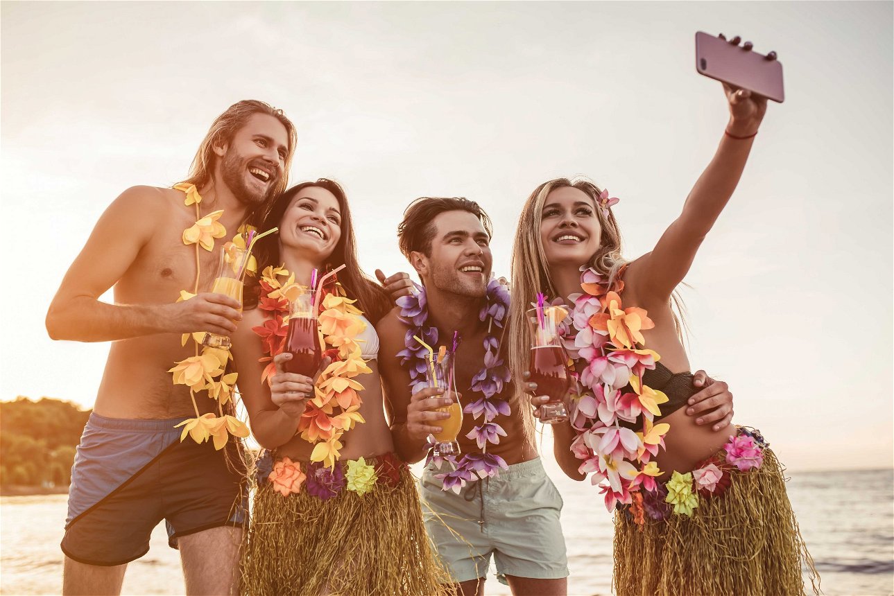ragazzi a una festa hawaiiana fanno un selfie