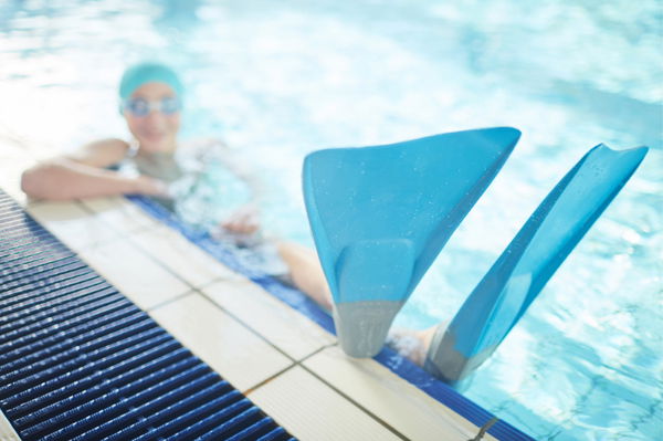 donna in piscina con pinne corte