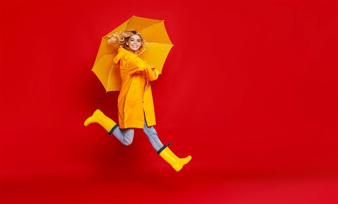 giovane donna con ombrello e stivali per la pioggia
