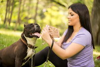 ragazza che mette la museruola al suo cane