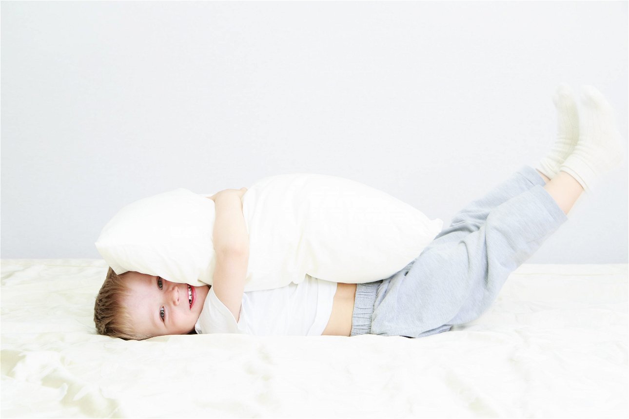 bambino che abbraccia un cuscino