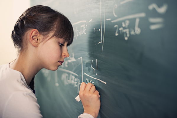 bambina che scrive su lavagna di gesso