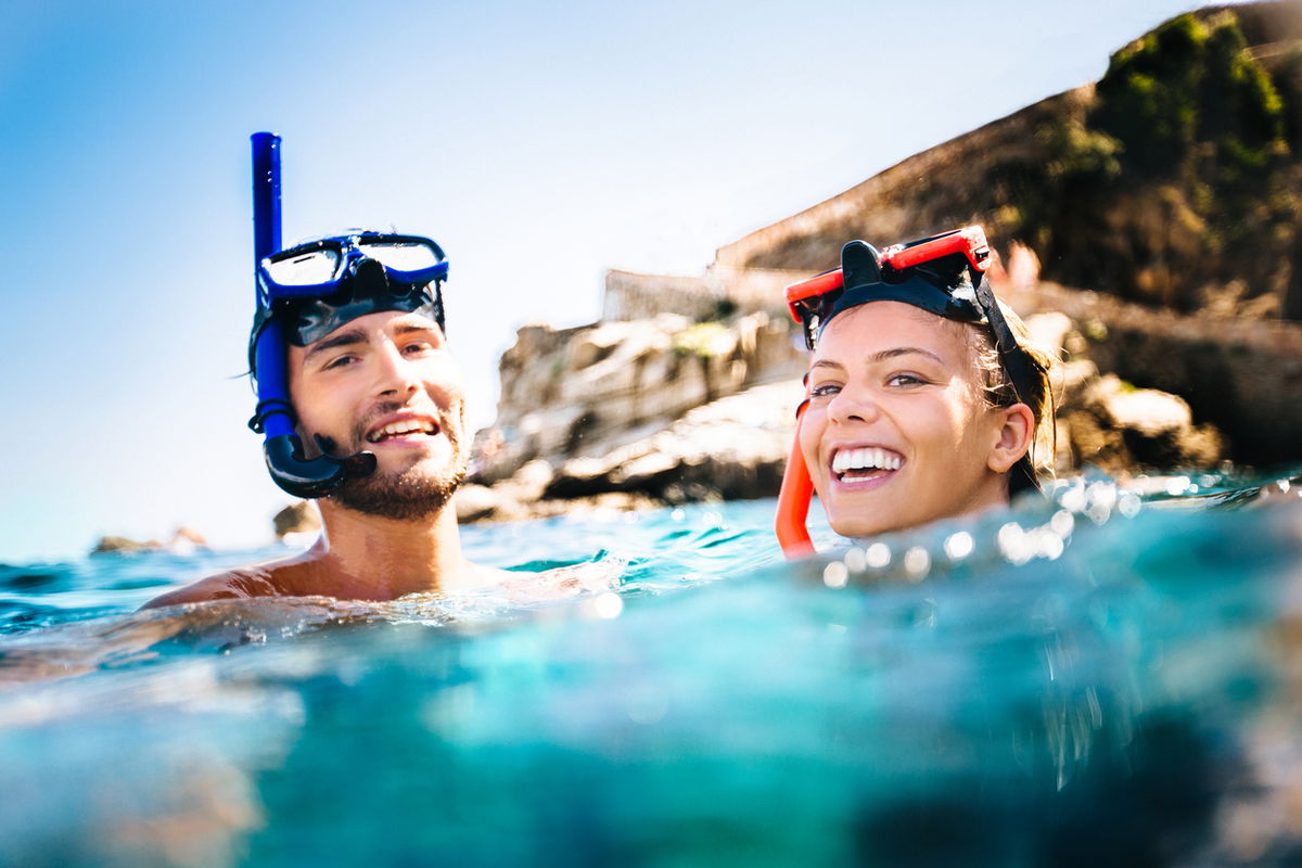 uomo e donna in acqua con maschere e boccaglio