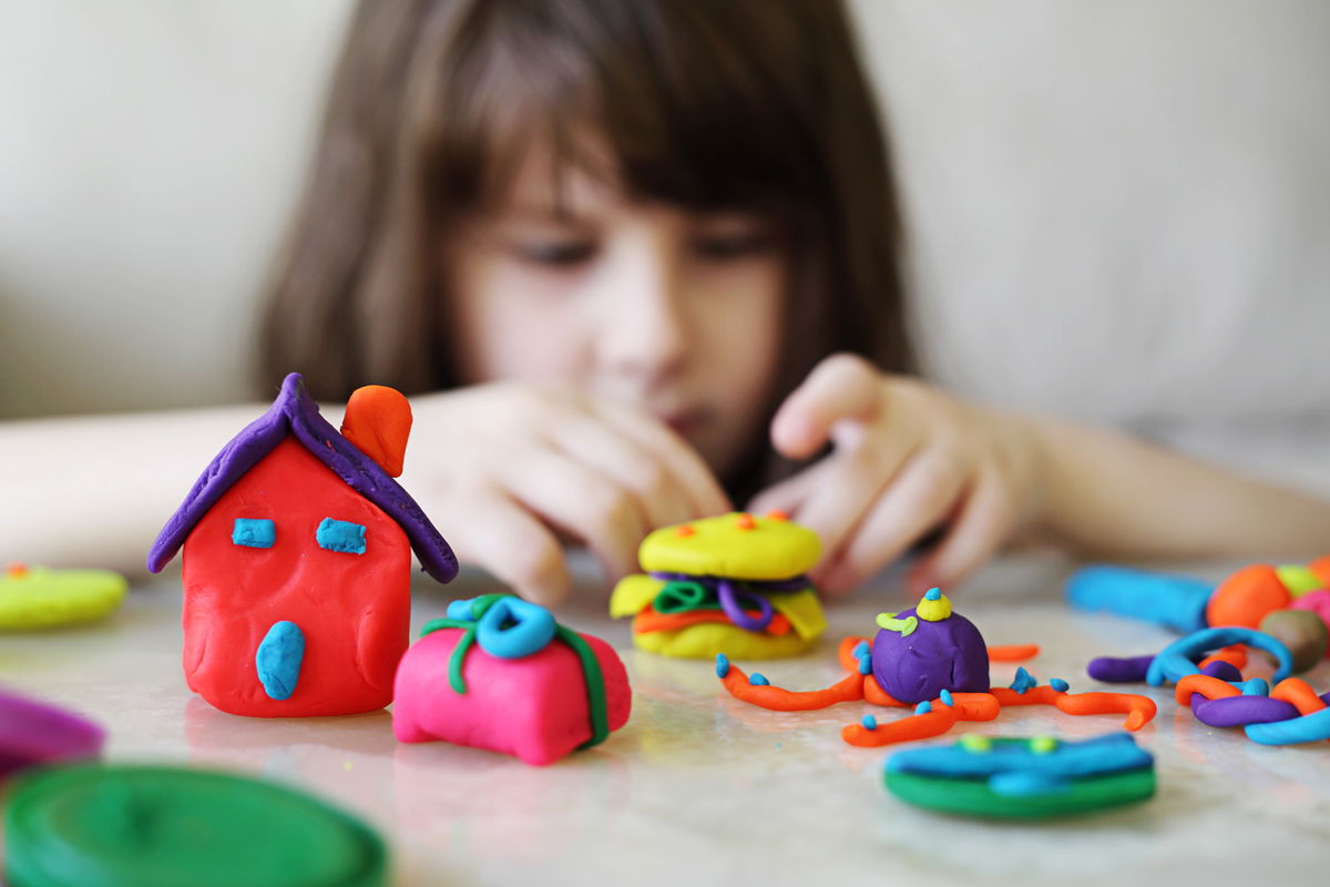 bambina che gioca con Play Doh